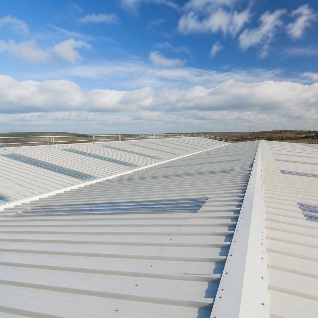 Insulated corrugated roof panels installed across a large steel-framed building